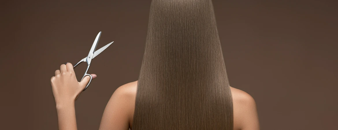 Kobieta ze zdrowymi włosami trzymająca nożyczki